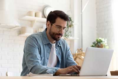Man in blue shirt at laptop computer